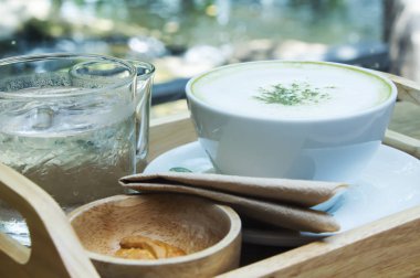 Ahşap arka plan üzerinde tozu matcha yeşil çay sütlü.