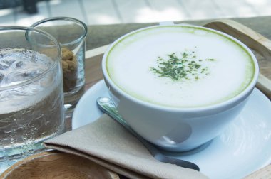 Ahşap arka plan üzerinde tozu matcha yeşil çay sütlü.