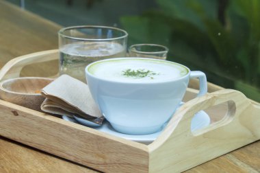 Ahşap arka plan üzerinde tozu matcha yeşil çay sütlü.