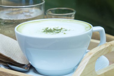 Ahşap arka plan üzerinde tozu matcha yeşil çay sütlü.