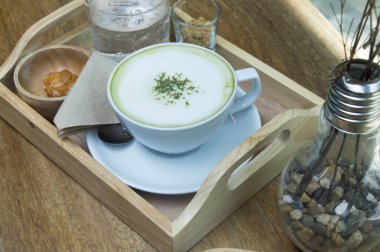 Ahşap arka plan üzerinde tozu matcha yeşil çay sütlü.