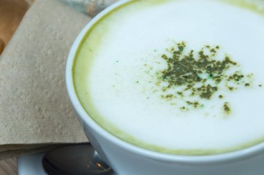 Ahşap arka plan üzerinde tozu matcha yeşil çay sütlü.