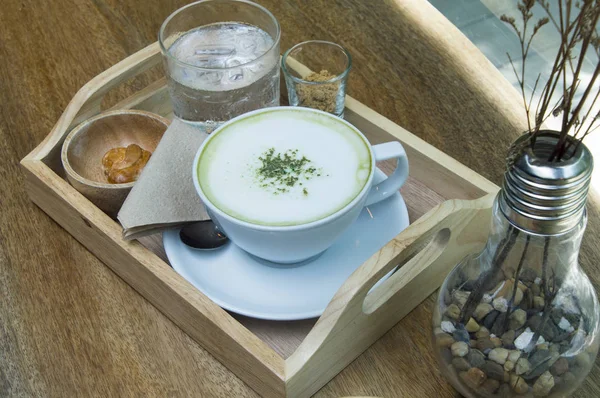 Ahşap arka plan üzerinde tozu matcha yeşil çay sütlü.