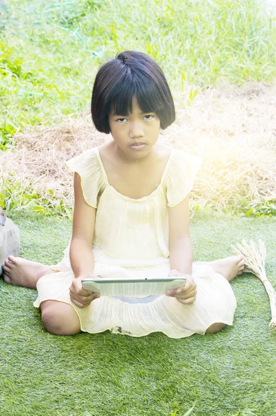 Gelukkig weinig Aziatisch meisje geniet van het spelen in de tuin. — Stockfoto
