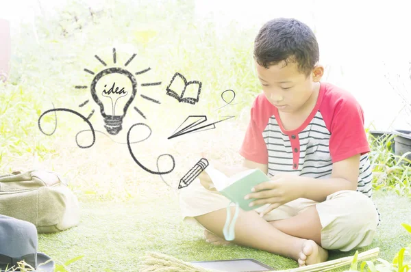 Gelukkig weinig Aziatische jongen heeft veel idee afgestudeerd in de tuin. — Stockfoto