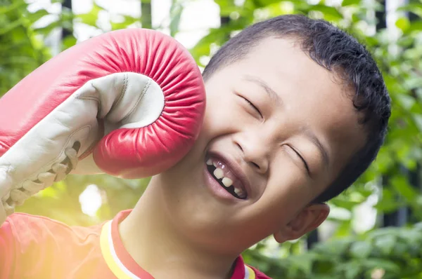 Feliz asiático chico usando un boxer guantes oin el jardín . — Foto de Stock