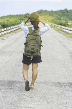 Gün batımı tepe mou üzerinde zevk sırt çantası ile yürüyen Gezgin kadın