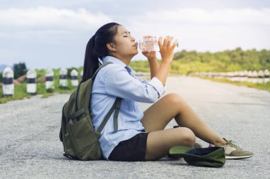 Oturma ve sunse zevk sırt çantası ile içme Gezgin kadın