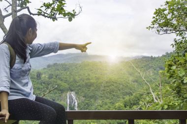 Genç kadın sırt çantası waterfa ile açık rahatlatıcı ile seyahat