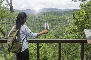 Genç kadın sırt çantası waterfa ile açık rahatlatıcı ile seyahat