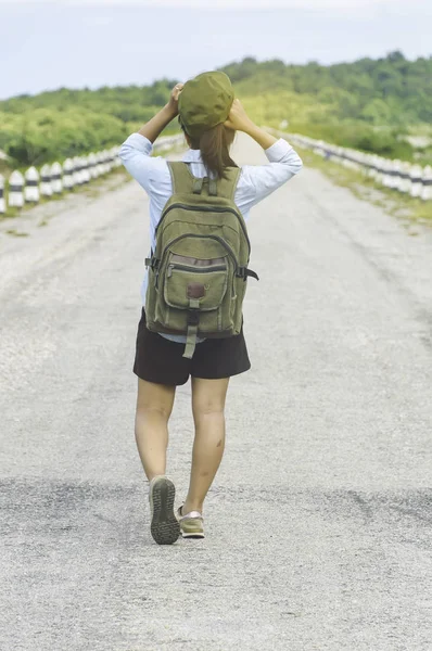 Gün batımı tepe mou üzerinde zevk sırt çantası ile yürüyen Gezgin kadın