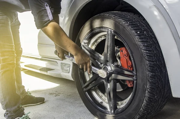 Mecánico automático utiliza un neumático de cambio de coche en repai coche profesional —  Fotos de Stock