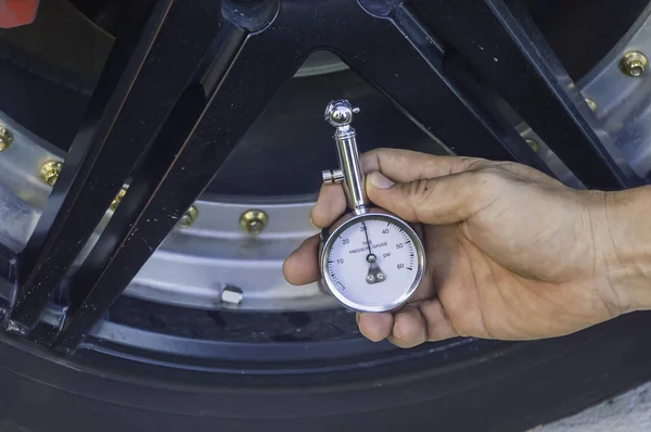 Автомеханик Ручной манометр для измерения давления в шинах автомобиля — стоковое фото