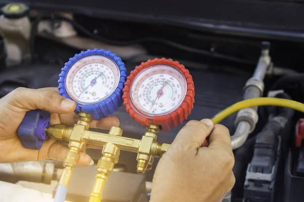 Automechaniker verwendet ein Manometer am Luftkompressor, Flüssigkeit lizenzfreie Stockbilder