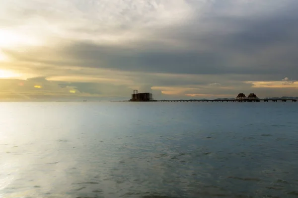 A longa ponte sobre o mar com um belo nascer do sol . — Fotografia de Stock