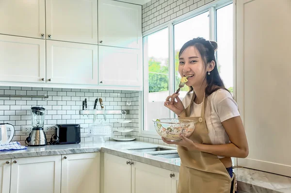 Schön asiatische junge Frau ist suchen zu Kochen in Küche bei — Stockfoto