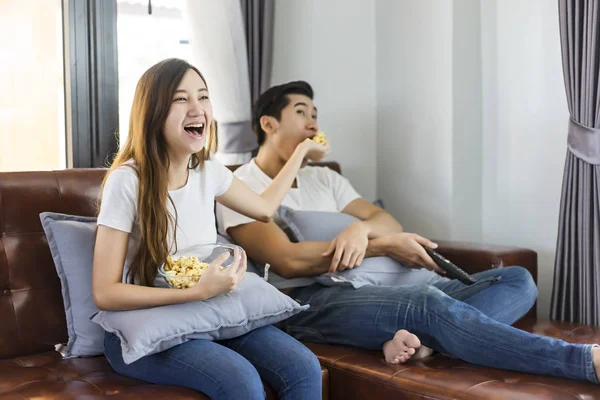 Szczęśliwa para młoda Azjatka na kanapie oglądając film razem. — Zdjęcie stockowe