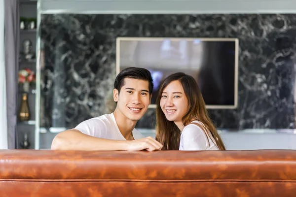 Young married couple sitting on the couch and watching tv at hom — Stock Photo, Image