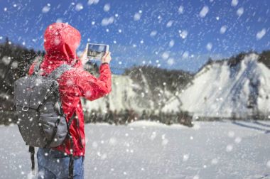 Genç adam kış kar alan orman, turist olarak fotoğraf çekme