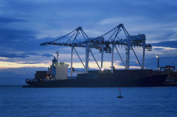 Containers que carregam pelo guindaste no por do sol, porto de comércio, transporte — Fotografia de Stock