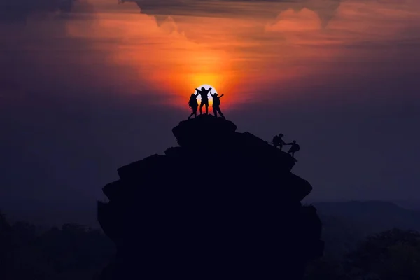 Silueta lezení po horském útesu a jeden tým turisty — Stock fotografie