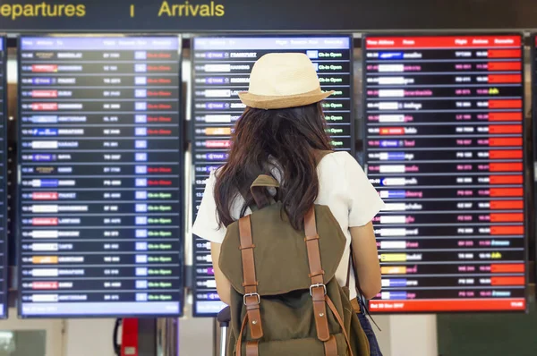 Mujer joven con mochila y equipaje de mano en internacional — Foto de Stock