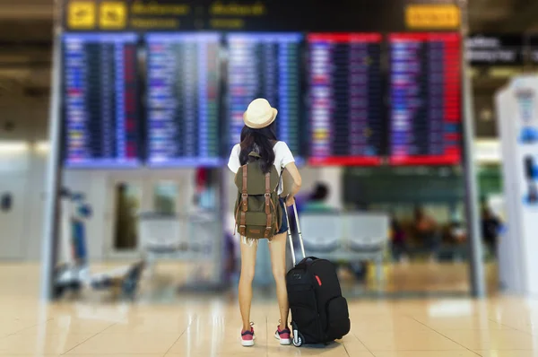 Mujer joven con mochila y equipaje de mano en internacional —  Fotos de Stock