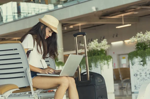 Mujer joven en el aeropuerto a la espera de viajar en avión con la tableta. Ella... — Foto de Stock