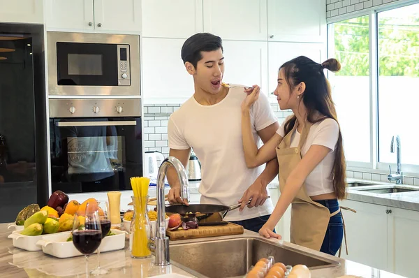 Mooie Aziatische jonge paar lief lachend op zoek zijn naar cooki — Stockfoto