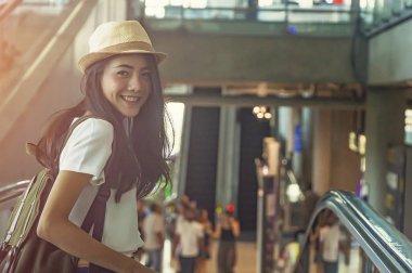 Yürüyen merdivenden aşağı bavullu genç kız..