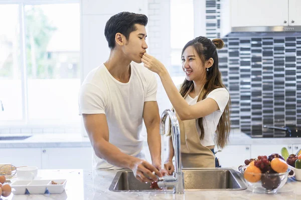 Beautiful asian young couple loving smiling is looking to cookin