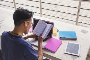 Üniversitesi lise kampüsünde, colle dizüstü bilgisayar kullanan adam