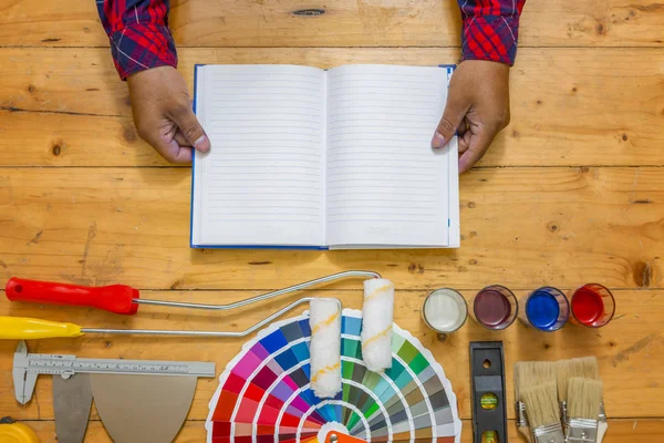 Mãos segurando DIY treinamento manual aberto com ferramentas de trabalho, cor sw — Fotografia de Stock