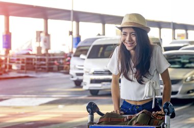 Havaalanında akıllı telefon kullanarak hava yolculuğu için bekleyen genç kadın.
