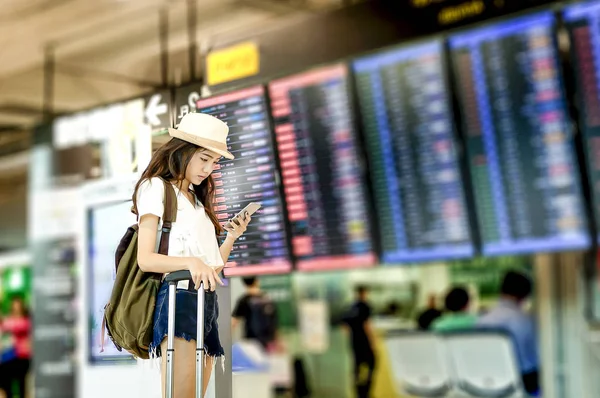 Mujer joven con mochila y equipaje de mano en internacional — Foto de Stock