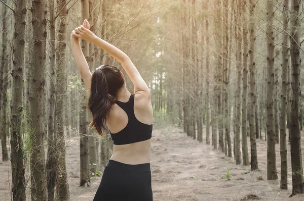 Güzel kadın sportif dinlenme sonra ormandaki kasları rahatla