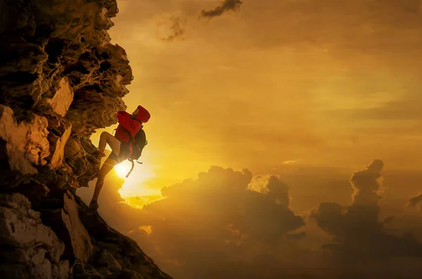 Femme escalade une falaise au cours d'une belle Images De Stock Libres De Droits