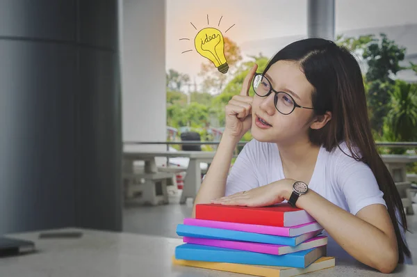 Pensando idea estudiante chica con gafas y libros en el escritorio, Aburrido — Foto de Stock