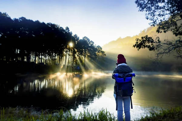 Beautiful woman travel morning sunrise and tourist camping on the lake with foggy in the morning,Pang Ung, Mea Hong Son,North of Thailand.