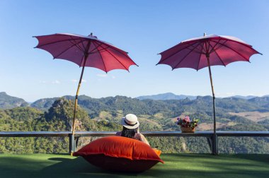 Buzlu çay içen ve cep telefonu kullanan güzel genç bir kadın..