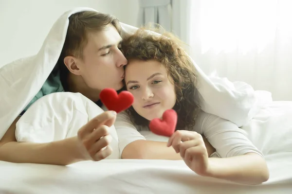 Piękny kochający para całuje w łóżko — Zdjęcie stockowe