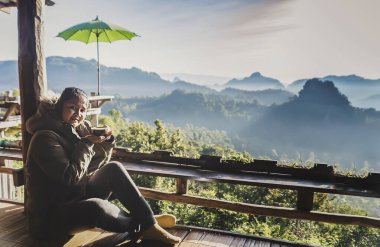 Sabahları sıcak kahve içen bir kadın. Kamp yürüyüşü