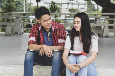 Kütüphanede kitaplarla çalışan mutlu genç üniversite öğrencileri. Üniversitede bir grup çok ırklı insan.