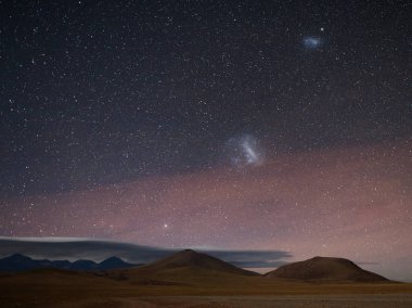 Gece manzarası: Canopus ve Magellanic Bulutları Atacama Çölü 'nde And Dağları' nın üzerinde yükseliyor 