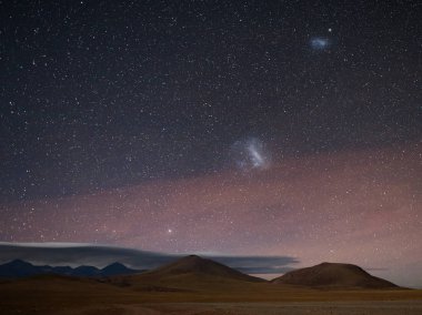 The nightscape: Canopus and Magellanic Clouds rises above Andes at Atacama desert  clipart