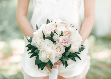 Gelin elinde bir buket çiçek tutuyor.