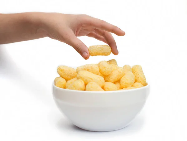 Hand nimmt Maisstäbchen, die in einer weißen Tasse auf einem Tisch isolieren — Stockfoto