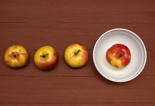 Pommes du magasin dans une tasse blanche, sur un fond brun, grand dessus — Photo