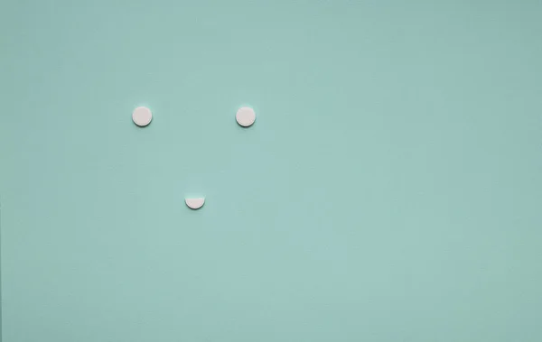 On a blue background white pills in the form of a large face — Stock Photo, Image