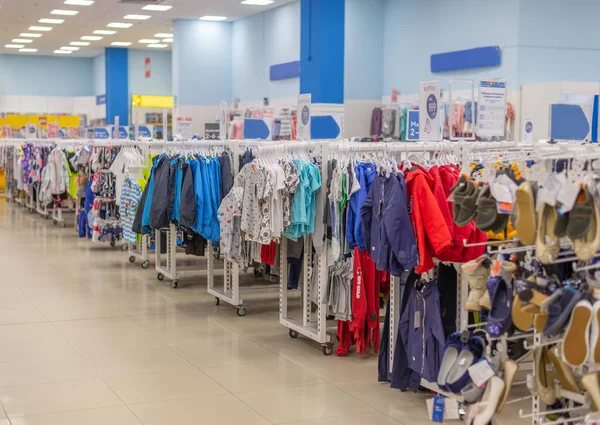 in the mall childrens clothes and shoes of different sizes on hangers and racks for sale